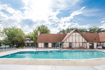 a swimming pool with a white building with a brown roof in the background  at Pheasant Run, Lafayette